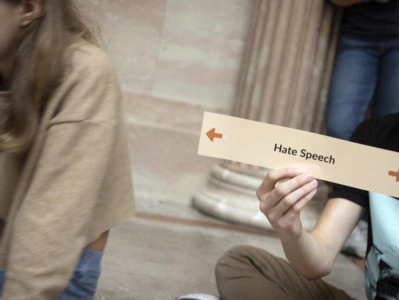 Schüler hält Schild mit "Hate Speech" hoch