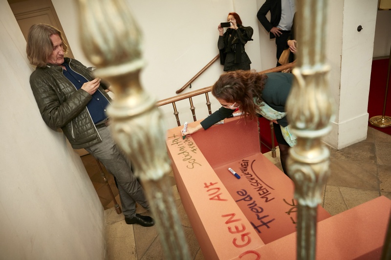 Justizministerin Alma Zadic (G) schreibt auf eine Kunstinstallation