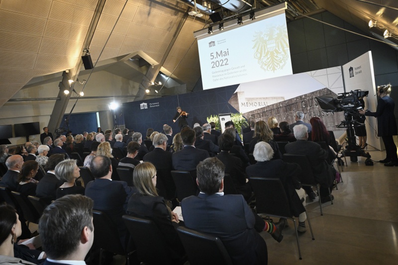 Musikalische Untermalung Aliosha Biz. Blick Richtung Veranstaltungsteilnehmer:innen