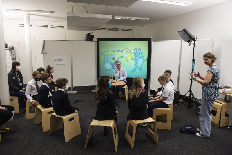 Schüler:innen der Klasse 4a im Theresianum in der Demokratiewerkstatt. Bildmitte: Leiter der Abteilung Parlamentswissenschaftliche Grundsatzarbeit Christoph Konrath. Rechte Seite: Ö1 Redakteurin