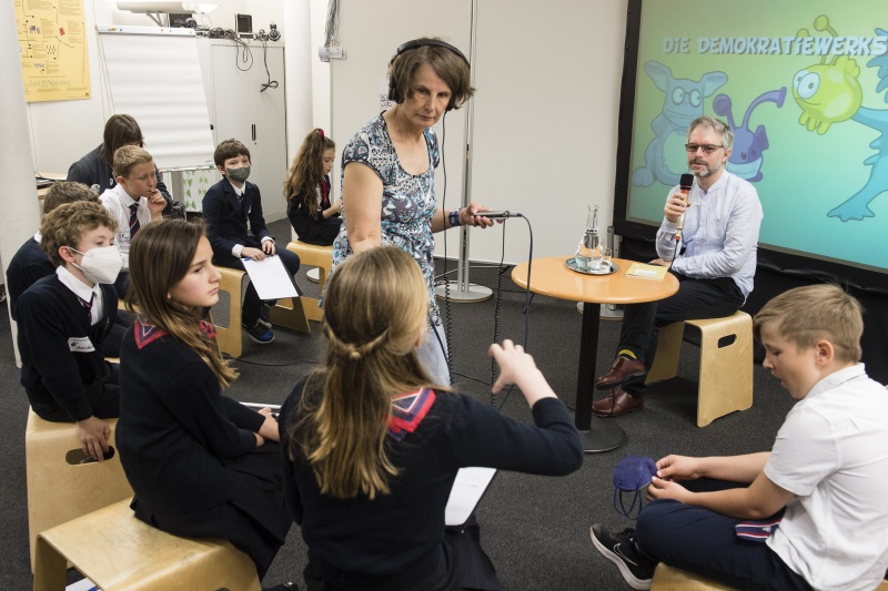 Schüler:innen der Klasse 4a des Theresianum in der Demokratiewerkstatt. Rechte Seite: Leiter der Abteilung Parlamentswissenschaftliche Grundsatzarbeit Christoph Konrath. Bildmitte: Ö1 Redakteurin