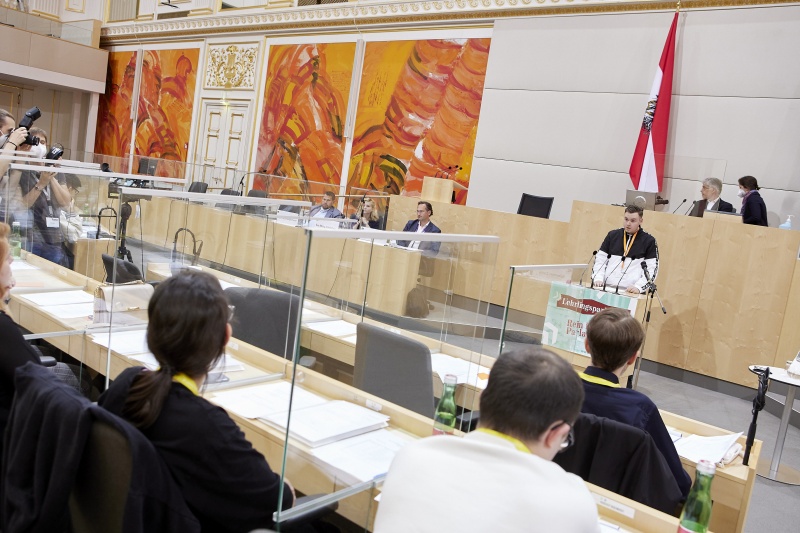 Teilnehmer:innen am Rednerpult