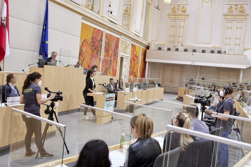 Teilnehmer:innen am Rednerpult