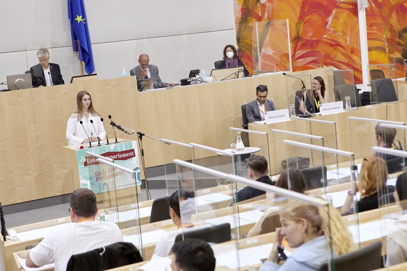 Teilnehmer:innen am Rednerpult