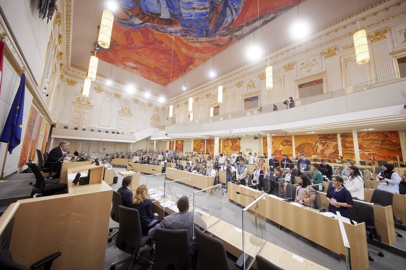 Teilnehmer:innen bei der Abstimmung im Plenum