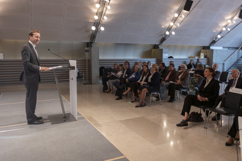 Am Rednerpult: Jakob Calice und Teilnehmer:Innen...