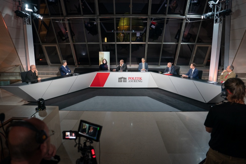 Podium von links: Nationalratsabgeordneter Michel Reimon (Grüne), Nationalratsabgeordneter Helmut Brandstätter (NEOS), ORF Raffaela Schaidreiter, Moderator Gerald Groß, Universität Wien Patrick Müller, Nationalratsabgeordneter Harald Troch (SPÖ), Nationalratsabgeordneter Nico Marchetti (ÖVP), Nationalratsabgeordneter Johannes Hübner (FPÖ)