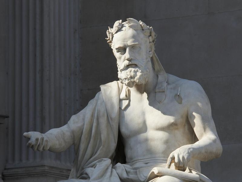 Darstellung des griechischen Geschichtsschreibers Xenophon mit Lorbeerkranz und Philosophenbart, geöffnete Schriftrolle und dem Besucher entgegen gestreckte Hand. Künstler Hugo Härdtl, 1899, Laaser Marmor. Von Ringstraßenseite links neben dem Brunnen.