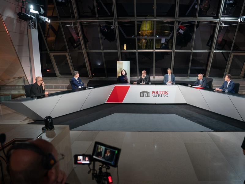 Podium von links: Nationalratsabgeordneter Michel Reimon (Grüne), Nationalratsabgeordneter Helmut Brandstätter (NEOS), ORF Raffaela Schaidreiter, Moderator Gerald Groß, Universität Wien Patrick Müller, Nationalratsabgeordneter Harald Troch (SPÖ), Nationalratsabgeordneter Nico Marchetti (ÖVP), Nationalratsabgeordneter Johannes Hübner (FPÖ)
