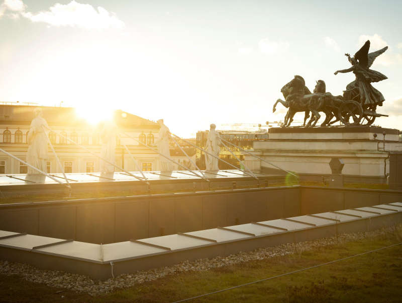 Quadriga and rooftop statues during sunset