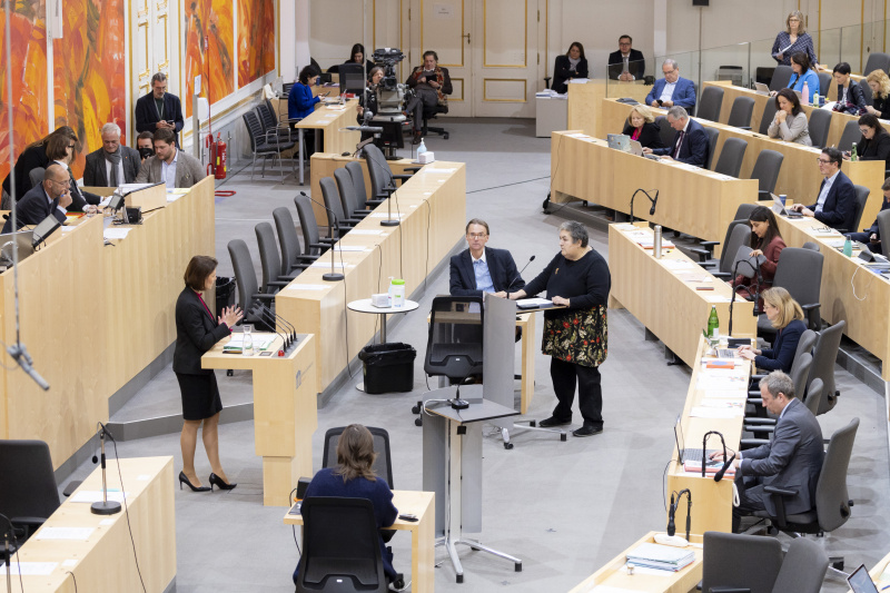 Blick Richtung Sitzungsteilnehmer:innen. Am Rednerpult links Europaministerin Karoline Edtstadler (ÖVP), am Rednerpult rechts Nationalratsabgeordnete Eva Blimlinger (GRÜNE)