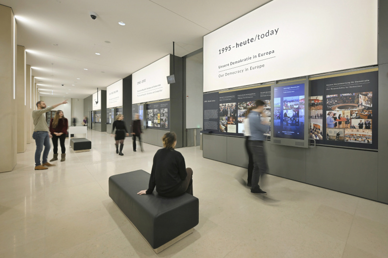 Agora, Wandstation "Demokratie mit Geschichte" - Besucher:innen besichtigen die Exponate