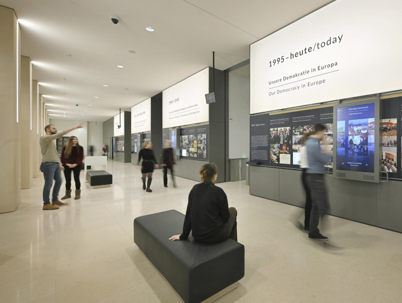 Agora, Wandstation \x22Demokratie mit Geschichte\x22 - Besucher:innen besichtigen die Exponate