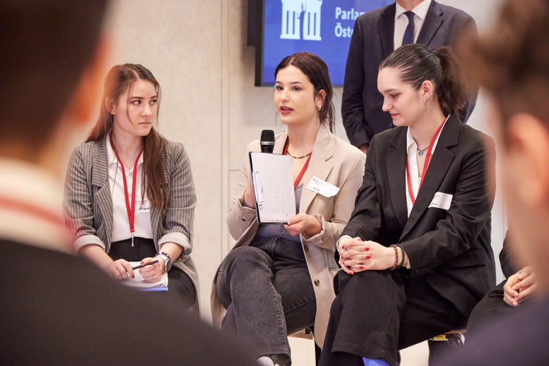 Veranstaltungsteilnehmer:innen stellen Fragen