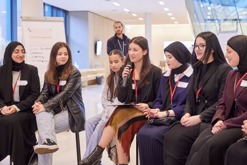 Veranstaltungsteilnehmer:innen stellen Fragen