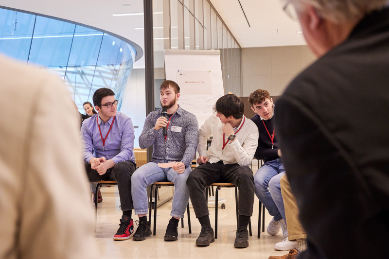 Veranstaltungsteilnehmer:innen stellen Fragen