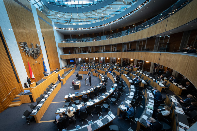 Blick Richtung Sitzungsteilnehmer:innen, Nationalratsabgeordneter Reinhold Einwallner (SPÖ) und Nationalratsabgeordneter Gerald Loacker (NEOS) am Rednerpult
