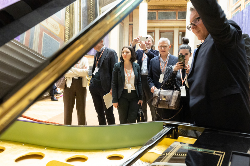 Veranstaltungsteilnehmer:innnen besichtigen das Goldene Klavier