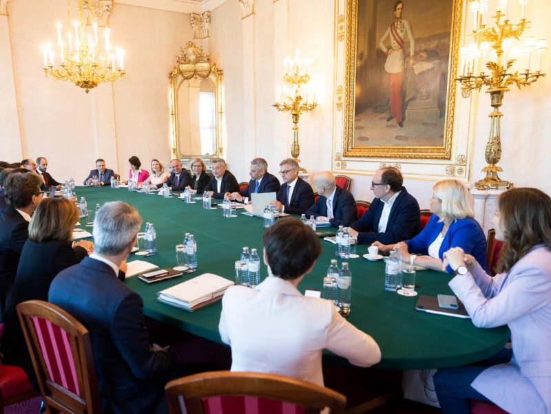 Minister:innen sitzen an ovalem, grünem Tisch