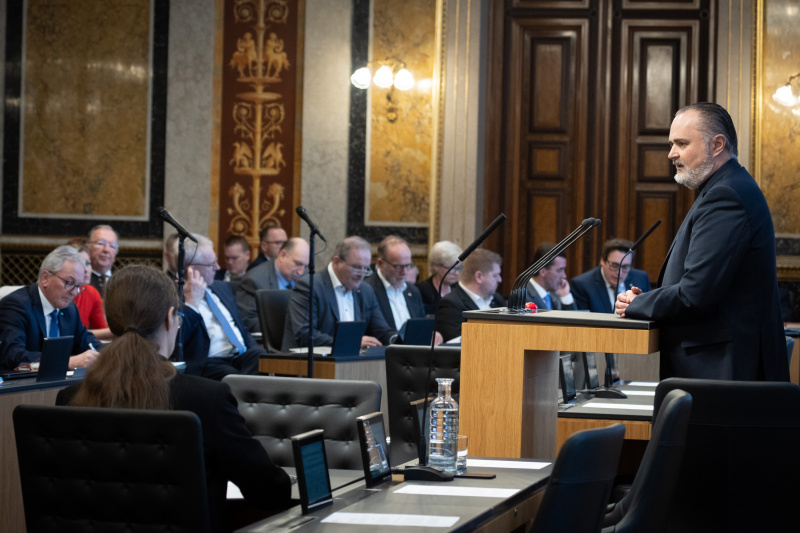  Landeshauptmann Burgenland Hans-Peter Doskozil am Redner:innenpult. Blick Richtung Sitzungsteilnehmer:innen