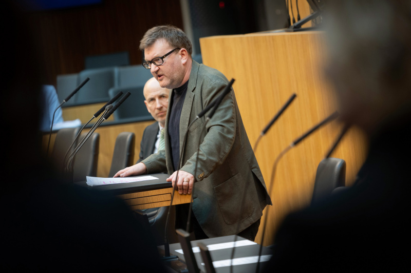 Nationalratsabgeordneter Markus Koza (GRÜNE) am Redner:innenpult, Bundesminister für Arbeit Martin Kocher auf der Regierungsbank