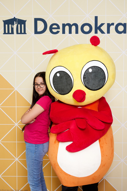 Fotopoint mit den Maskottchen der Demkratiewerkstatt und Schüler:innen