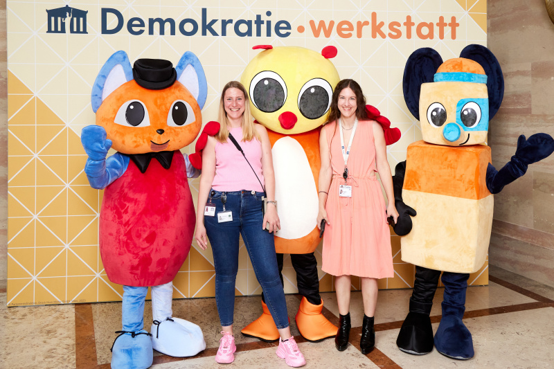 Fotopoint mit den Maskottchen der Demkratiewerkstatt und Schüler:innen