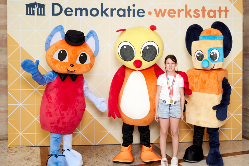 Fotopoint mit den Maskottchen der Demkratiewerkstatt und Schüler:innen