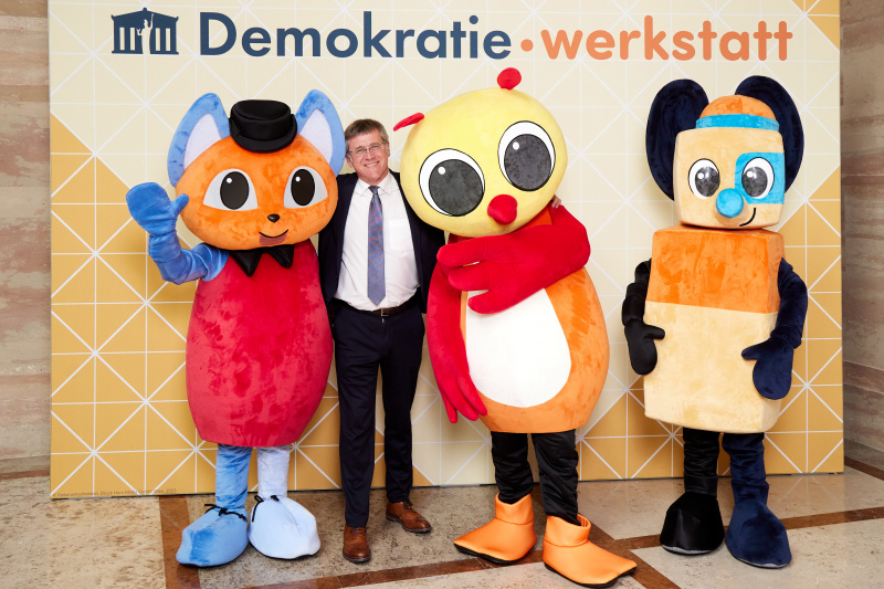 Fotopoint mit den Maskottchen der Demkratiewerkstatt und Schüler:innen