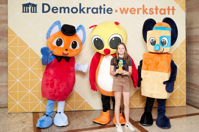 Fotopoint mit den Maskottchen der Demkratiewerkstatt und Schüler:innen