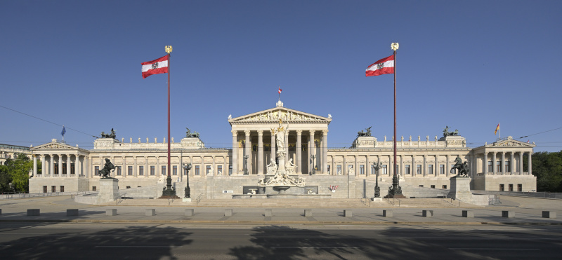 Blick auf die Fassade des beflaggten Parlamentsgebäudes von der Ringstraßenseite