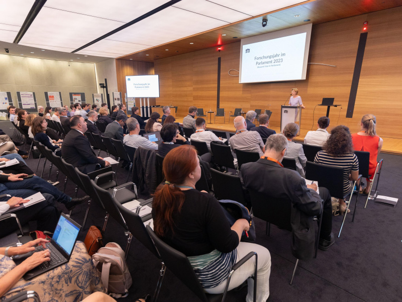 Publikum und Bühne sind zu sehen, am Rednerpult spricht Parlamentsvizedirektorin Susanne Janistyn-Novák