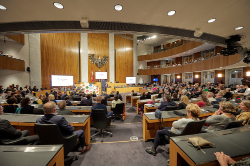 Abschließende Worte von Vorstandsvorsitzenden Senat der Wirtschaft Hans Harrer. Blick auf die Veranstaltungsteilnehmer:innen.