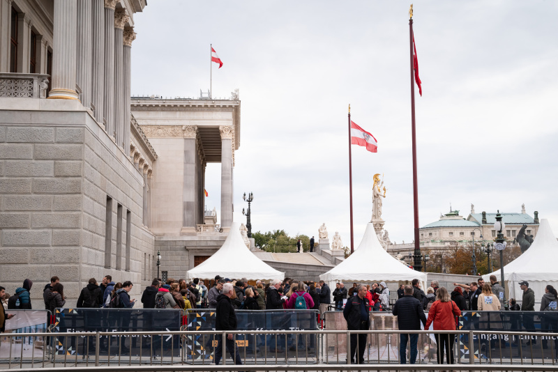 Wartende Verantaltungsteilnehmer:innen vor dem Parlament