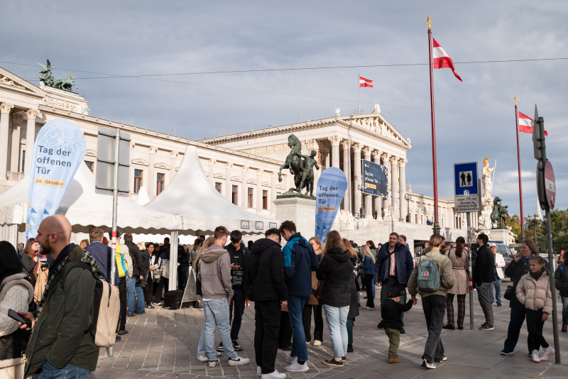 Wartende Verantaltungsteilnehmer:innen vor dem Parlament