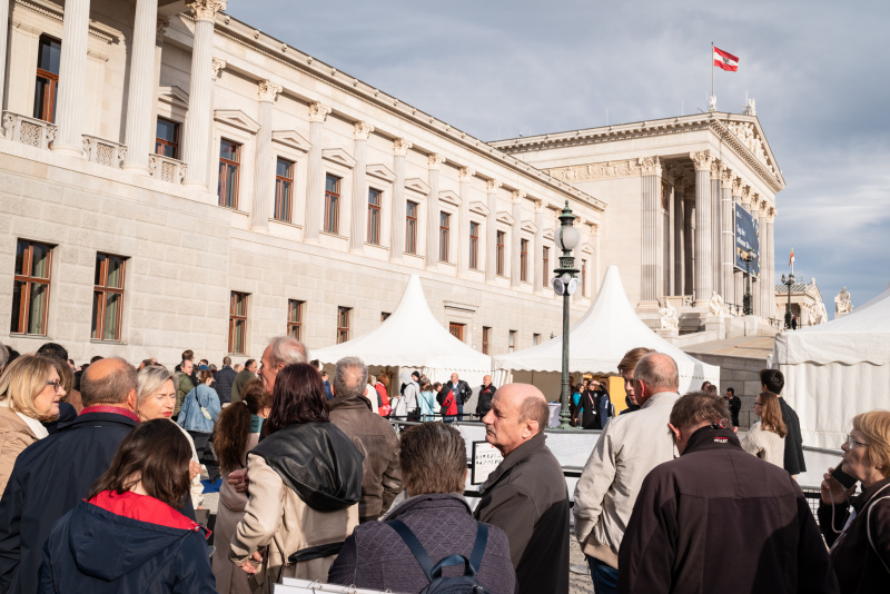 Wartende Verantaltungsteilnehmer:innen vor dem Parlament