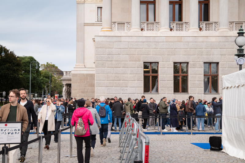 Wartende Verantaltungsteilnehmer:innen vor dem Parlament