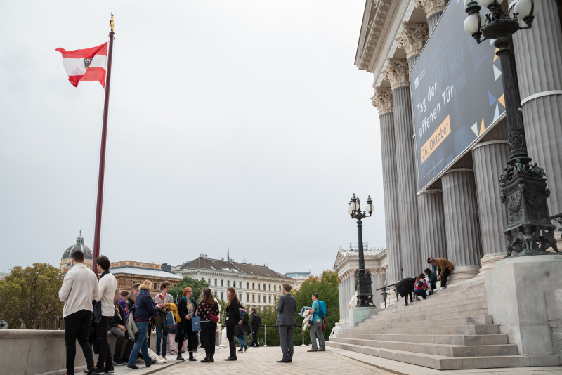 Verantaltungsteilnehmer:innen verlassen das Parlamentsgebäude über die Rampe