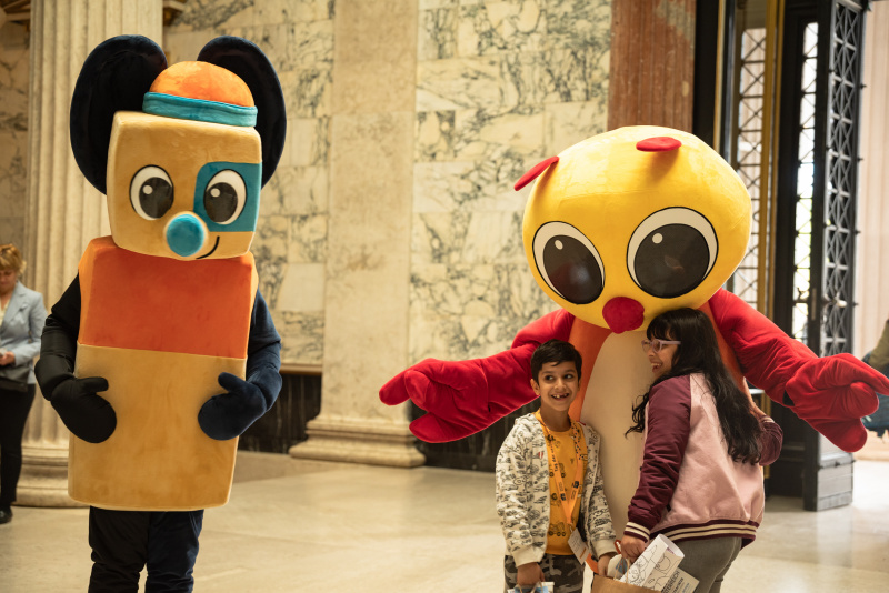 Maskottchen der Demokratiewerkstatt mit Verantaltungsteilnehmer:innen