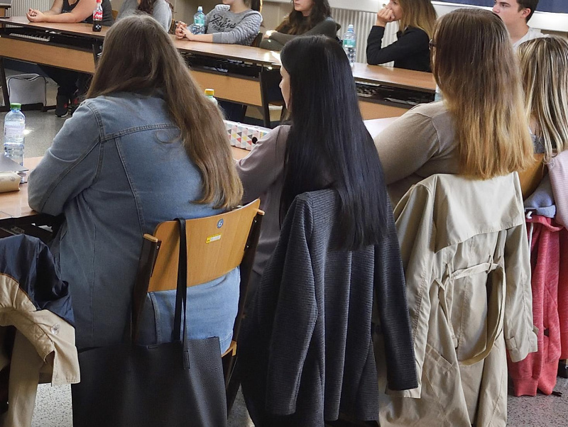 Einige Schüler:innen sitzen in einem Klassenzimmer und folgen dem Unterricht