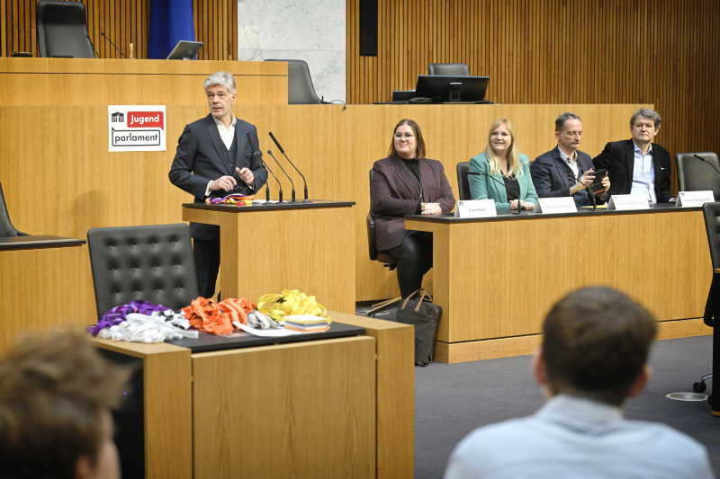 Begrüßung. Am Rednerpult Parlamentsdirektor Harald Dossi. Regierungsbank von links: Nationalratsabgeordnete Carina Reiter (ÖVP), Nationalratsabgeordnete Elisabeth Feichtinger (SPÖ), Nationalratsabgeordneter Hermann Weratschnig (GRÜNE), Nationalratsabgeordneter Helmut Brandstätter (NEOS)