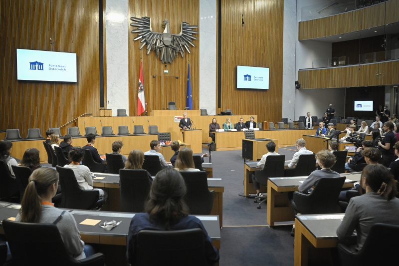 Begrüßung. Am Rednerpult Parlamentsdirektor Harald Dossi. Regierungsbank von links: Nationalratsabgeordnete Carina Reiter (ÖVP), Nationalratsabgeordnete Elisabeth Feichtinger (SPÖ), Nationalratsabgeordneter Hermann Weratschnig (GRÜNE), Nationalratsabgeordneter Helmut Brandstätter (NEOS)