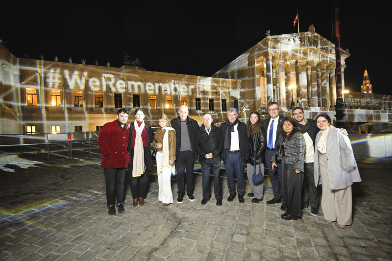 Gruppenfoto mit  Zeitzeuge Avraham Roet (5. von links), Israelischer Botschafter in Österreich David Roet (4. von rechts) und Veranstaltungsteilnehmer:innen vor dem Parlament