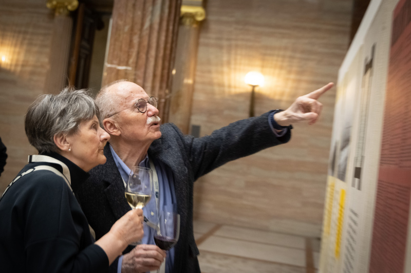 Veranstaltungsteilnehmer:innen betrachten die Bilder