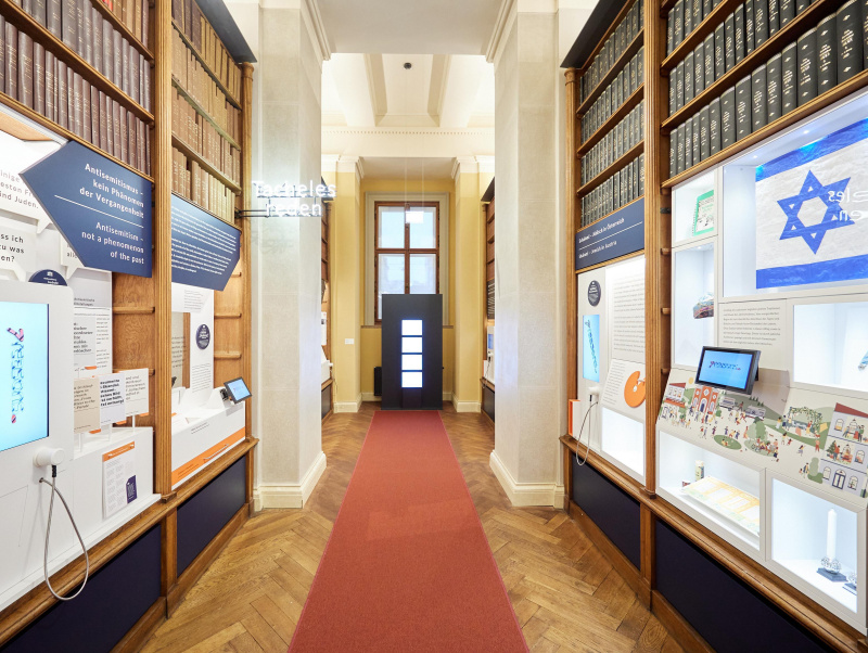 Blick in den Bibliotheksgang mit Ausstellungsobjekten