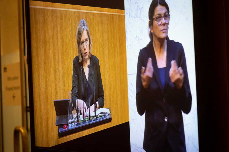 Am Display Umweltministerin Leonore Gewessler (GRÜNE) am Redner:innenpult, Gebärdendolmetscherin