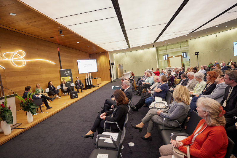 Podiumsdiskussion mit Vertreter:innen der Parlamentsfraktionen. Von links: JKU Alumni Club Michael Dickstein, Nationalratsabgeordnete Karin Doppelbauer (NEOS), Nationalratsabgeordnete Agnes Sirkka Prammer (GRÜNE), Nationalratsabgeordnete Susanne Fürst (FPÖ), Nationalratsabgeordnete Eva Maria Holzleitner (SPÖ), Nationalratsabgeordneter Nico Marchetti (ÖVP)
