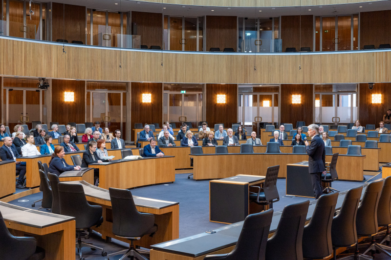 Begrüßungsworte von Parlamentsdirektor Harald Dossi. Blick Richtung Veranstaltungsteilnehmer:innen