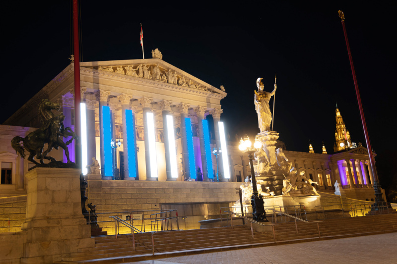 Weiß-Blaue Fassadenbeleuchtung am Parlamentsgebäude zum Gedenktag