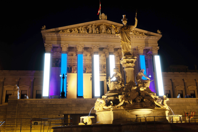 Weiß-Blaue Fassadenbeleuchtung am Parlamentsgebäude zum Gedenktag